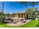 Community park featuring a covered picnic area with seating, barbecue grills, and nearby playground equipment at 104 E Louis Way, Tempe, AZ 85284