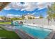 Backyard pool area featuring a waterfall, poolside seating, and lush landscaping for outdoor relaxation at 104 E Louis Way, Tempe, AZ 85284