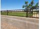 Backyard features block wall and wrought iron fence with view of grass and trees at 10624 W Sonrisas St, Tolleson, AZ 85353