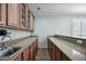 Dry bar area featuring light wood cabinets, granite counters, and a sink at 11785 N 143Rd Dr, Surprise, AZ 85379