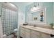 Bathroom features a white vanity, framed mirror, and shower with blue patterned shower curtain at 11785 N 143Rd Dr, Surprise, AZ 85379
