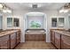 Bathroom featuring dual sinks, soaking tub, and a large window for natural light at 11785 N 143Rd Dr, Surprise, AZ 85379