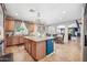 Open kitchen layout with tile floors, wood cabinets, a large island, and views to the living room at 11785 N 143Rd Dr, Surprise, AZ 85379