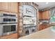 Kitchen with stainless appliances, stone hood range, stone arch, and lots of natural light at 11785 N 143Rd Dr, Surprise, AZ 85379