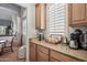 This coffee bar is located in the kitchen and has wood cabinets and a granite countertop at 11785 N 143Rd Dr, Surprise, AZ 85379