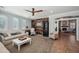 Spacious living room with wood accent wall, ceiling fan, large windows, and neutral tones at 11785 N 143Rd Dr, Surprise, AZ 85379