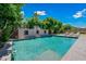 Backyard pool view showcasing the pool's clear water, surrounding greenery, and tanning chairs under a bright blue sky at 11785 N 143Rd Dr, Surprise, AZ 85379