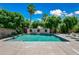 Backyard swimming pool surrounded by lush landscaping and lounge chairs under a blue sky at 11785 N 143Rd Dr, Surprise, AZ 85379