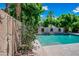 Outdoor shower and pool view featuring refreshing shower, vibrant flowers, and lush green landscaping creating a serene backyard escape at 11785 N 143Rd Dr, Surprise, AZ 85379