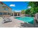 A refreshing backyard pool with lounge chairs and a custom outdoor kitchen on a sunny day at 11785 N 143Rd Dr, Surprise, AZ 85379