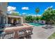 Beautiful backyard featuring pool, outdoor kitchen, fireplace, built-in bar and desert landscaping at 11785 N 143Rd Dr, Surprise, AZ 85379
