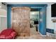 Open view from the living room with a rustic barn door, leading to a room with neutral carpet and blue walls at 11785 N 143Rd Dr, Surprise, AZ 85379