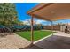Landscaped backyard featuring a covered patio, artificial turf, rock landscaping and a beautiful sea-life mural at 12109 N 127Th Dr, El Mirage, AZ 85335