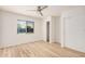 Bright bedroom features a ceiling fan, wood-look flooring, and window with blinds at 12109 N 127Th Dr, El Mirage, AZ 85335