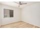 Spacious bedroom featuring a ceiling fan, light walls and wood-look flooring at 12109 N 127Th Dr, El Mirage, AZ 85335