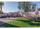 The landscaped backyard features synthetic grass, a brick paver area, and a decorative retaining wall at 13034 W Cheery Lynn Rd, Avondale, AZ 85392