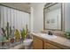 Well-lit bathroom with decorative cactus shower curtain and a single sink vanity at 13034 W Cheery Lynn Rd, Avondale, AZ 85392