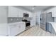 Updated kitchen featuring stainless steel appliances, white cabinets, tile backsplash and walk-in pantry at 1361 E Sheffield Ave, Gilbert, AZ 85296