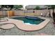 Backyard pool features a tiled water feature, concrete surround, and pebble landscaping at 14968 N 134Th Ln, Surprise, AZ 85379