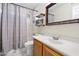 Bathroom featuring a shower-tub combo, sink, shelves and decorative mirror at 15034 S 44Th Pl, Phoenix, AZ 85044