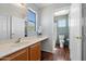 Well-lit bathroom with wood-look floors, large mirror, white vanity, and natural light from the window at 15034 S 44Th Pl, Phoenix, AZ 85044