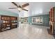 Large living room with a brick fireplace, ceiling fan, tile flooring, and built-in shelving at 15034 S 44Th Pl, Phoenix, AZ 85044