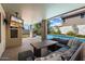 Comfortable covered patio with a sectional sofa, dining table, television, and a view of the pool area at 15034 S 44Th Pl, Phoenix, AZ 85044