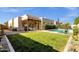 View of backyard with manicured lawn, covered patio, and sparkling pool, perfect for outdoor entertaining at 1554 E Kings Ct, Gilbert, AZ 85234