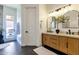 Bright bathroom boasting a wood vanity, double sinks, modern lighting, and access to the outdoor patio at 1554 E Kings Ct, Gilbert, AZ 85234