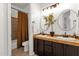 Functional bathroom with double sinks, dark wood cabinets, and a separate shower and toilet area at 1554 E Kings Ct, Gilbert, AZ 85234
