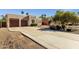 Charming home featuring a stucco facade, desert landscaping, and a spacious driveway leading to a two-car garage at 1554 E Kings Ct, Gilbert, AZ 85234