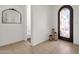 Bright foyer featuring tile flooring, a decorative mirror, and an arched doorway with a wrought iron gate at 1554 E Kings Ct, Gilbert, AZ 85234