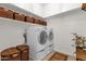 Clean laundry room featuring a washer, dryer, and built-in shelves for organized storage at 1554 E Kings Ct, Gilbert, AZ 85234