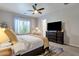 Comfortable bedroom featuring soft carpet, a ceiling fan, and dark wood furniture at 1554 E Kings Ct, Gilbert, AZ 85234