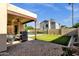 Outdoor patio area with grill, seating, and view of the pool and backyard, perfect for entertaining at 1554 E Kings Ct, Gilbert, AZ 85234