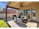 Covered patio with a ceiling fan, comfortable seating, and a view of the landscaped backyard, ideal for relaxation at 1554 E Kings Ct, Gilbert, AZ 85234