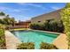 Beautiful backyard pool with clear blue water surrounded by lush landscaping and a patio area at 1554 E Kings Ct, Gilbert, AZ 85234