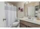 Bathroom featuring a vanity with a sink, toilet, shower with curtain, and mirror at 16675 W Taylor St, Goodyear, AZ 85338