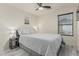 Well-lit bedroom features a ceiling fan, side table, and window with blinds at 16675 W Taylor St, Goodyear, AZ 85338