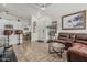 Open concept living room showcasing tile floors, a ceiling fan, a leather couch and a breakfast bar to the kitchen at 16675 W Taylor St, Goodyear, AZ 85338