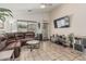 Comfortable living room featuring tile floors, a ceiling fan, a sectional couch and a media center at 16675 W Taylor St, Goodyear, AZ 85338