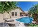 Inviting backyard with a sparkling pool, lounge chairs, and lush greenery at 16675 W Taylor St, Goodyear, AZ 85338