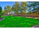 Expansive backyard with lush green grass and mature trees at 1681 S Karen Dr, Chandler, AZ 85286