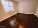 Bright bedroom features hardwood floors, white trim, and a window with plantation shutters at 1681 S Karen Dr, Chandler, AZ 85286