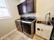 This laundry room features modern appliances, a sink with storage, and under cabinet lighting at 1681 S Karen Dr, Chandler, AZ 85286