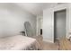 Neutral bedroom with beige carpet and walls, features a large mirror and ensuite bathroom at 17344 W Red Fox Rd, Surprise, AZ 85387