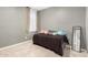Bedroom with neutral walls, plush carpet, black bed frame, and a decorative mirror at 17344 W Red Fox Rd, Surprise, AZ 85387