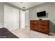 Bedroom featuring a double door closet, neutral walls, and an accent dresser at 17344 W Red Fox Rd, Surprise, AZ 85387