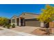 Inviting single-story house with a two-car garage and desert landscaping, offering great curb appeal at 17344 W Red Fox Rd, Surprise, AZ 85387