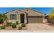 Charming home featuring a two-car garage, desert landscaping, and inviting front entrance at 17344 W Red Fox Rd, Surprise, AZ 85387